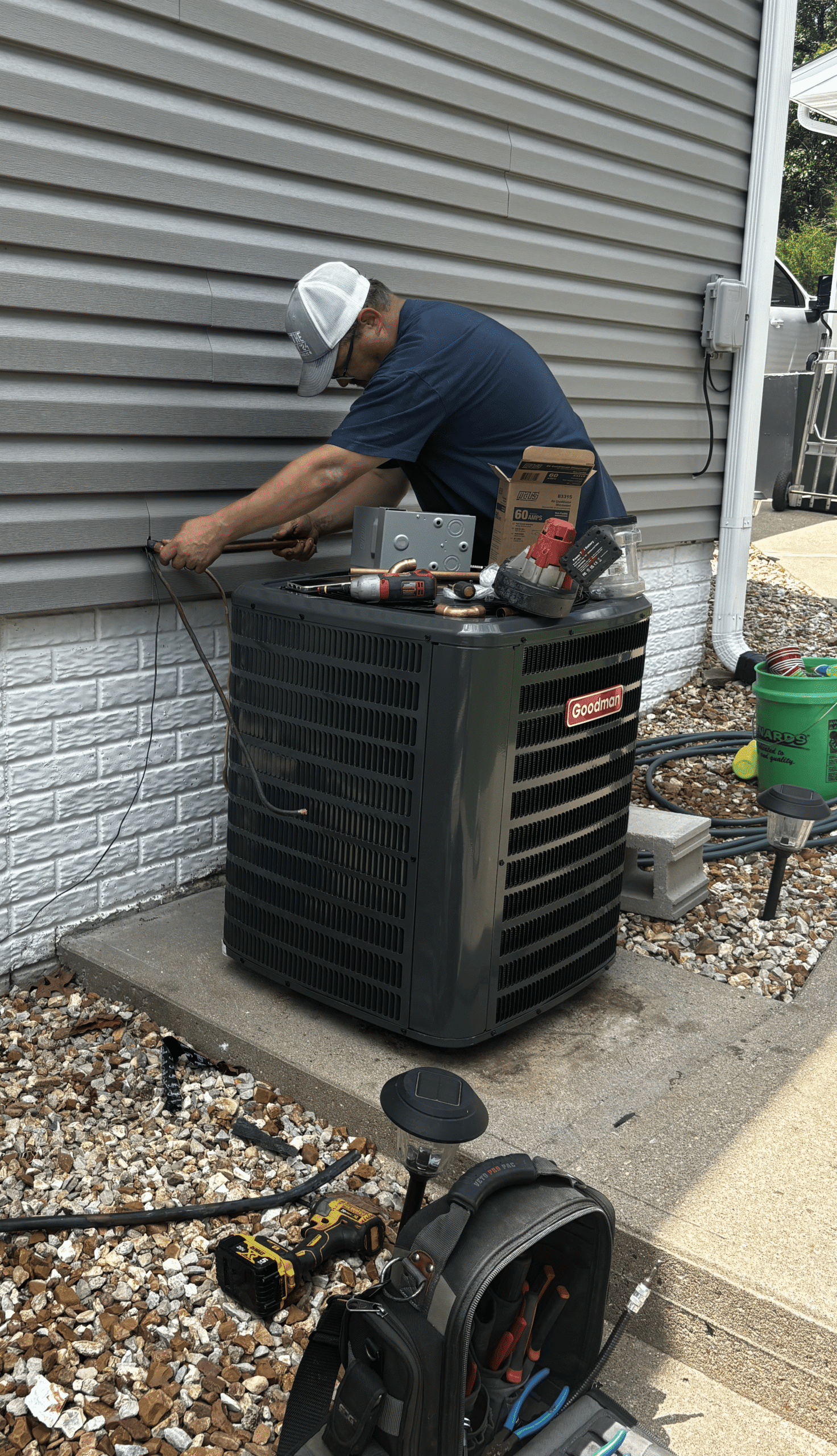 Cooling HVAC technician servicing a residential air conditioning unit in Lake of the Ozarks and Central Missouri